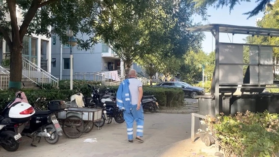 9月20日下午,北京某小区内,六十多岁的河南环卫工结束一天的工作,往住处走去。他住在单位提供的铁皮房里,三四人同住一间。摄影/郑可书